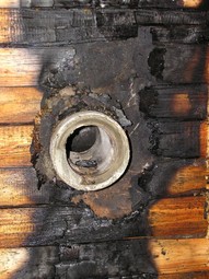 Obrzek 9 – Por devn stny pi prchodu kouovodu do komna vedenho u fasdy budovy. Msto certifikovan prchodky byla pouita azbestocementov trouba.
