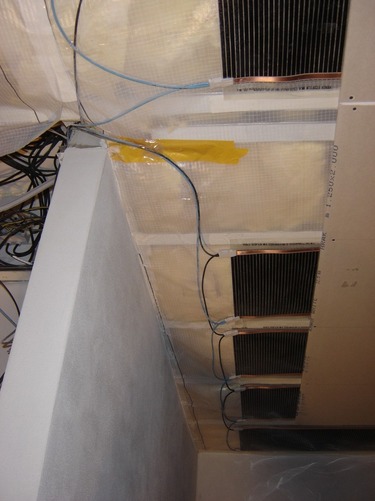 Částečně zaklopený systém stropního vytápění sádrokartonem. Pro vedení připojovacích kabelů a pro vývody na osvětlení je potřeba mezi jednotlivými fóliemi ponechat dostatečné odstupové vzdálenosti.